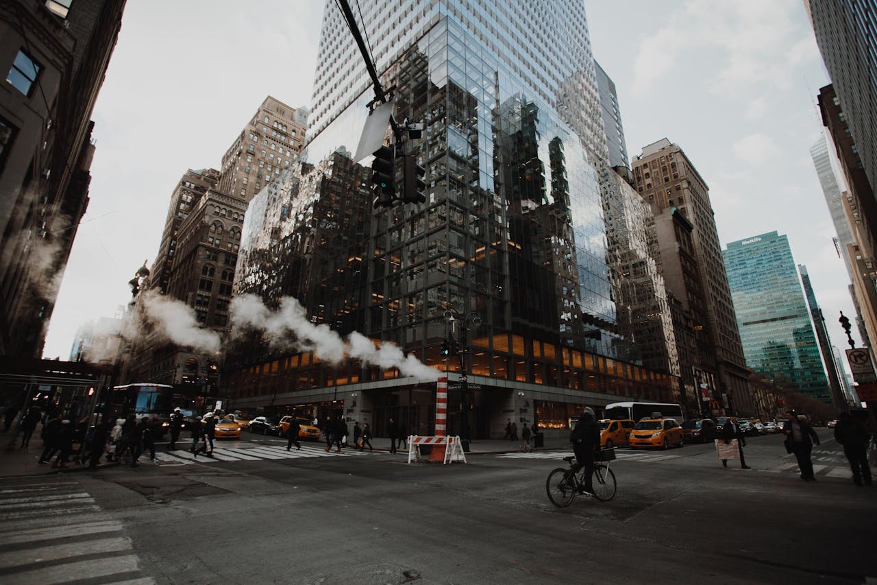 our-approach View of a busy intersection in New York City with skyscrapers and traffic.